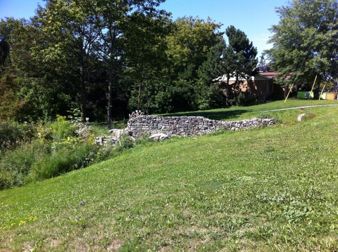Old foundation wall on a grassy slope
